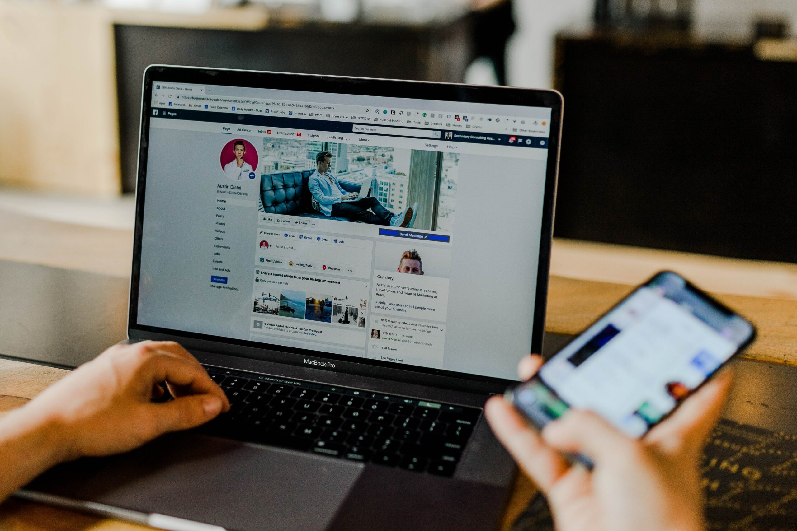 social media manager checking facebook on laptop and phone